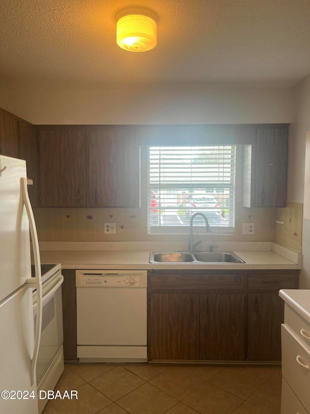 kitchen with white appliances, sink, dark brown cabinets, and light tile patterned floors