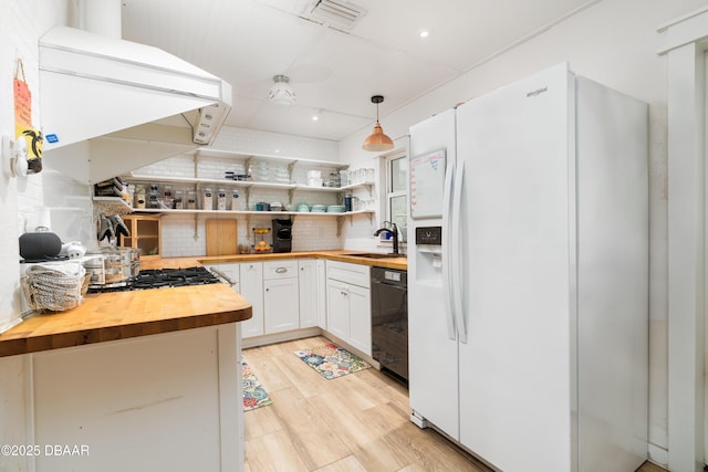 25 Dolphin Ave, Ormond Beach, FL 32176 - kitchen featuring wooden counters, white refrigerator with ice dispenser, backsplash, dishwashing machine, and white cabinetry