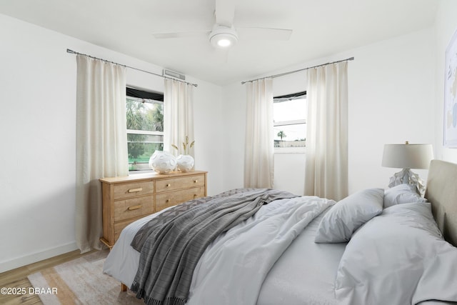 25 Dolphin Ave, Ormond Beach, FL 32176 - bedroom with light wood-style floors, multiple windows, baseboards, and ceiling fan