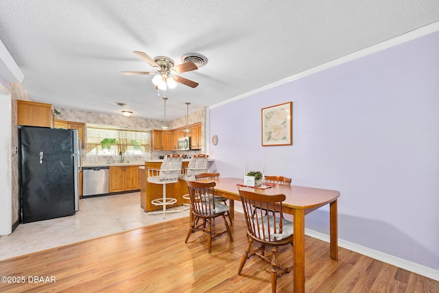 22 N St Andrews Dr, Ormond Beach, FL 32174 - dining space featuring a ceiling fan, light wood-style flooring, a textured ceiling, and ornamental molding
