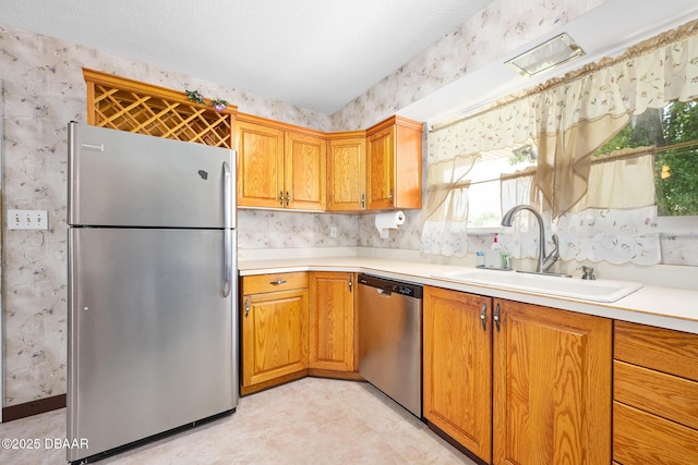 22 N St Andrews Dr, Ormond Beach, FL 32174 - kitchen featuring appliances with stainless steel finishes, wallpapered walls, light countertops, brown cabinetry, and light flooring
