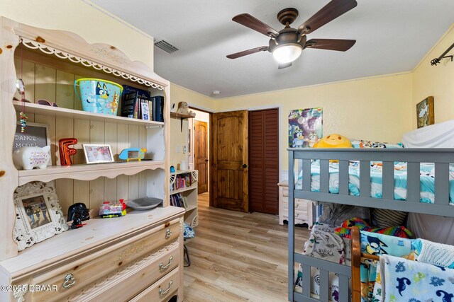 bedroom with a closet, ceiling fan, and light wood-type flooring