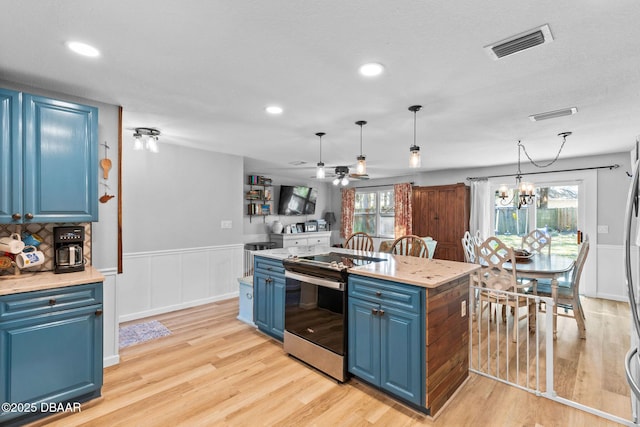 kitchen with blue cabinetry, hanging light fixtures, electric range, a kitchen island, and light hardwood / wood-style floors