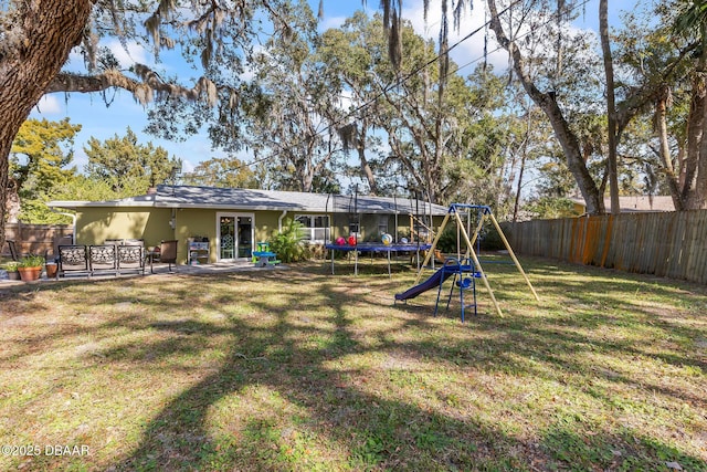 view of yard with a playground, a trampoline, and a patio area