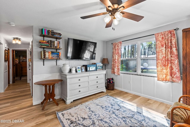 living area featuring ceiling fan and light hardwood / wood-style floors