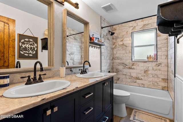 full bathroom featuring hardwood / wood-style floors, vanity, tiled shower / bath, and toilet