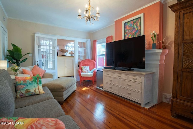 living room featuring dark hardwood / wood-style flooring, ornamental molding, and a chandelier