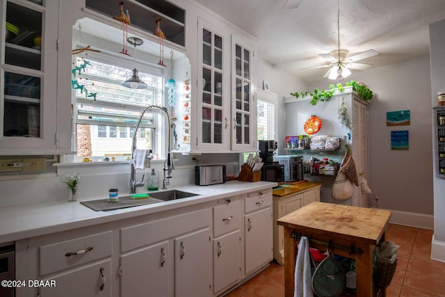 kitchen with white cabinets, hanging light fixtures, and a healthy amount of sunlight