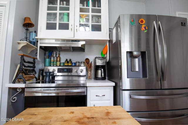 kitchen with butcher block countertops, white cabinetry, stainless steel appliances, and ventilation hood