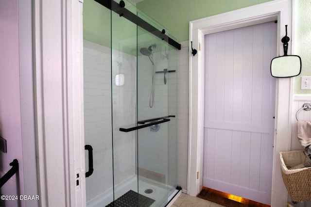 bathroom with a shower with shower door and hardwood / wood-style flooring