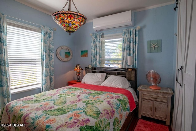 bedroom featuring a wall unit AC and multiple windows