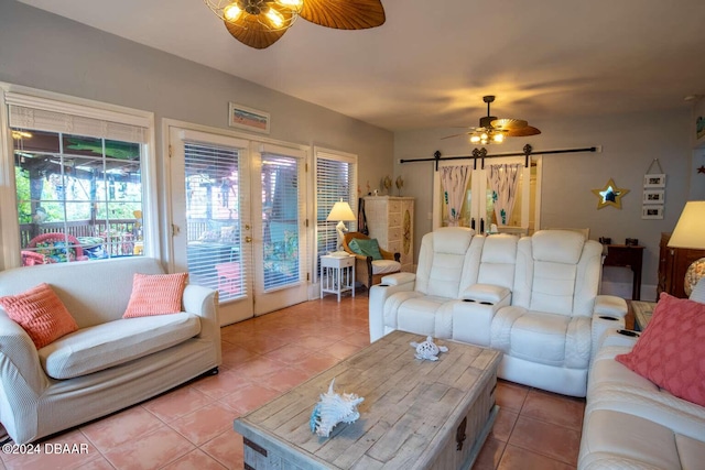 tiled living room with a barn door and ceiling fan