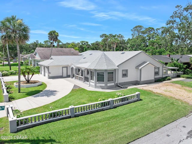 1650 Riverside Dr, Holly Hill, FL 32117 - rear view of house with curved driveway, a fenced front yard, stucco siding, and a shingled roof