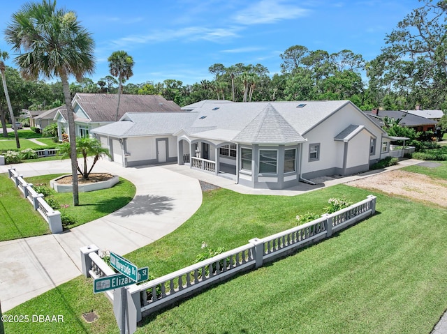 1650 Riverside Dr, Holly Hill, FL 32117 - rear view of house with curved driveway, an attached garage, roof with shingles, and stucco siding