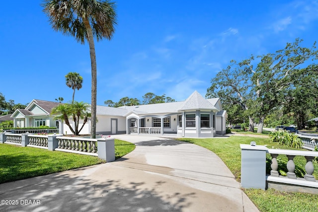 1650 Riverside Dr, Holly Hill, FL 32117 - view of front of home featuring concrete driveway, covered porch, a fenced front yard, and stucco siding