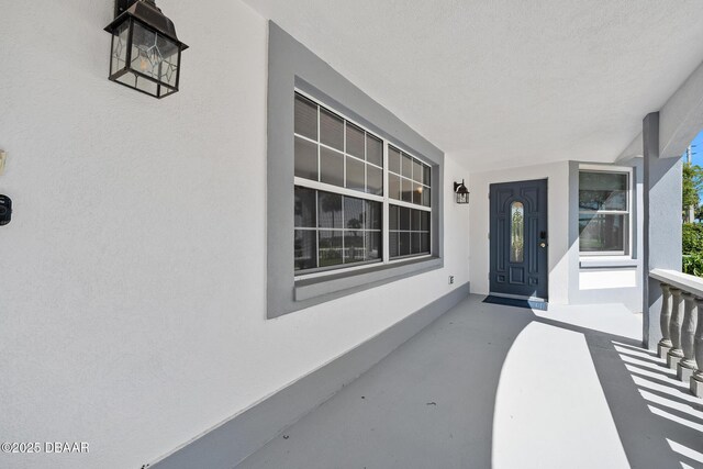 1650 Riverside Dr, Holly Hill, FL 32117 - doorway to property featuring stucco siding and covered porch