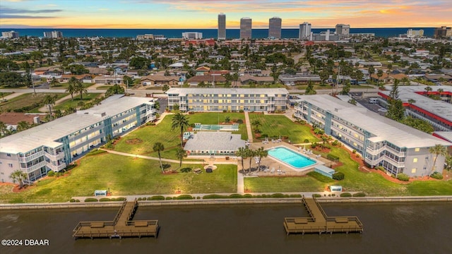 aerial view at dusk featuring a water view