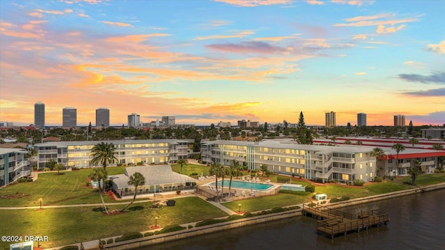 aerial view at dusk featuring a water view