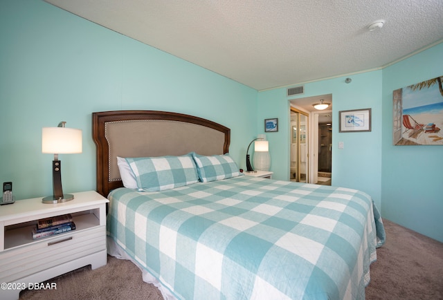 bedroom with a textured ceiling and carpet floors