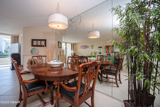 tiled dining room featuring a textured ceiling