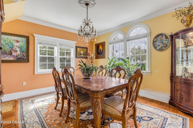 dining room with light wood-type flooring, a chandelier, and crown molding