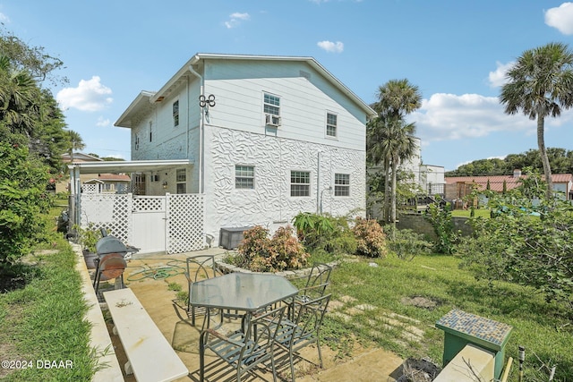 rear view of property with central AC unit, a yard, and a patio area