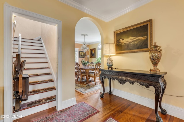 stairs with wood-type flooring and crown molding