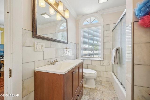 full bathroom with tile walls, enclosed tub / shower combo, ornamental molding, vanity, and toilet