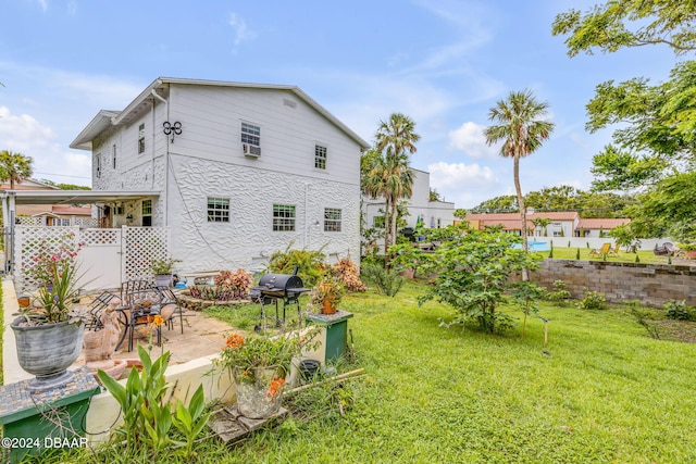 rear view of house featuring a yard and a patio area