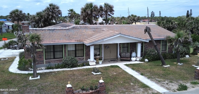 2944 Ocean Shore Blvd, Ormond Beach, FL 32176 - view of front facade with brick siding, a front lawn, and covered porch