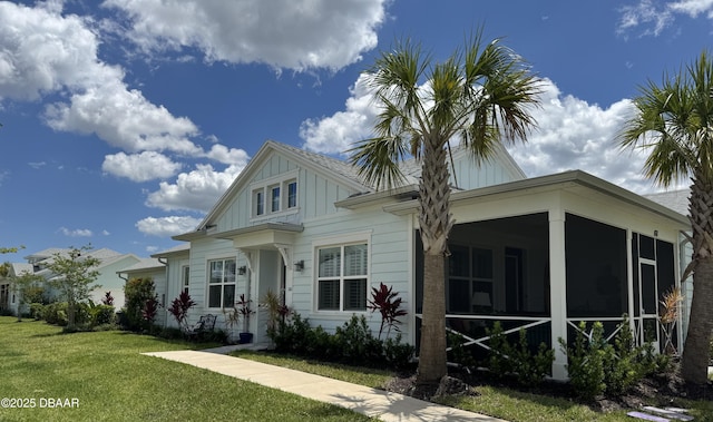 168 Ocean Hammock Loop, Daytona Beach, FL 32124 - view of front of property with a front yard, a sunroom, and board and batten siding