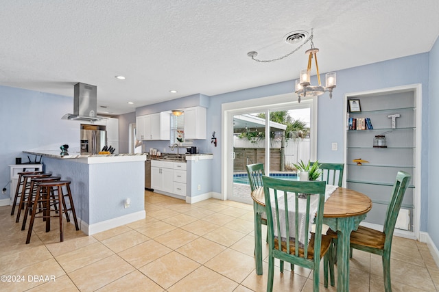 interior space with white cabinetry, light stone counters, stainless steel refrigerator with ice dispenser, pendant lighting, and exhaust hood