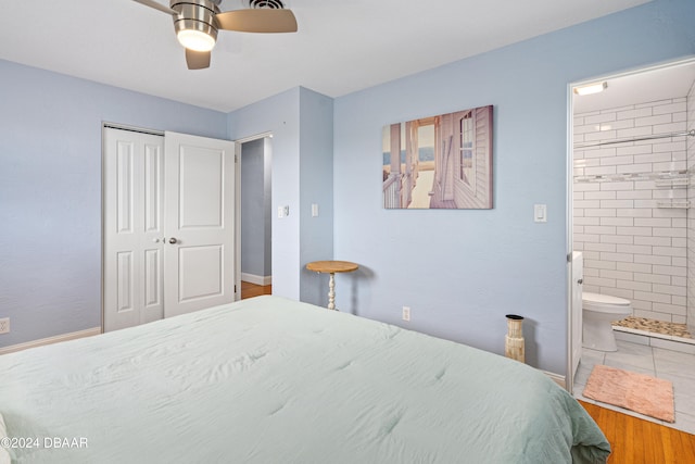 tiled bedroom with a closet, ensuite bath, and ceiling fan