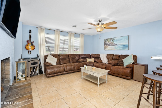 tiled living room featuring ceiling fan and a textured ceiling