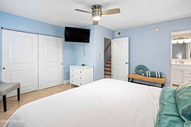 tiled bedroom with sink, ensuite bathroom, a closet, and ceiling fan