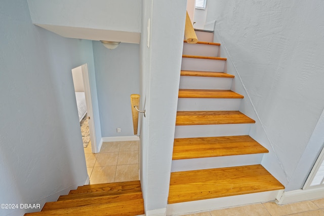 staircase featuring tile patterned flooring