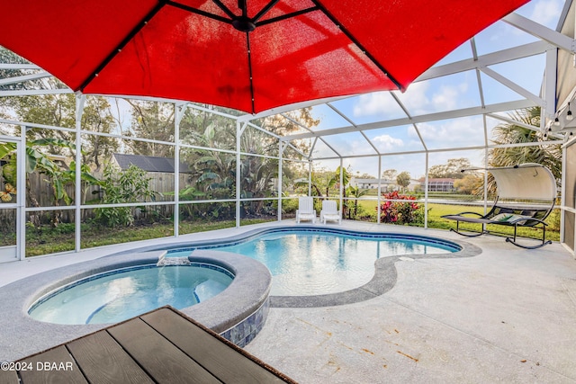 view of pool featuring a pool with connected hot tub, a lanai, and a patio