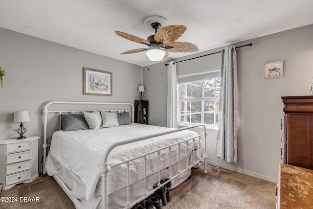 carpeted bedroom with ceiling fan, a textured ceiling, and baseboards