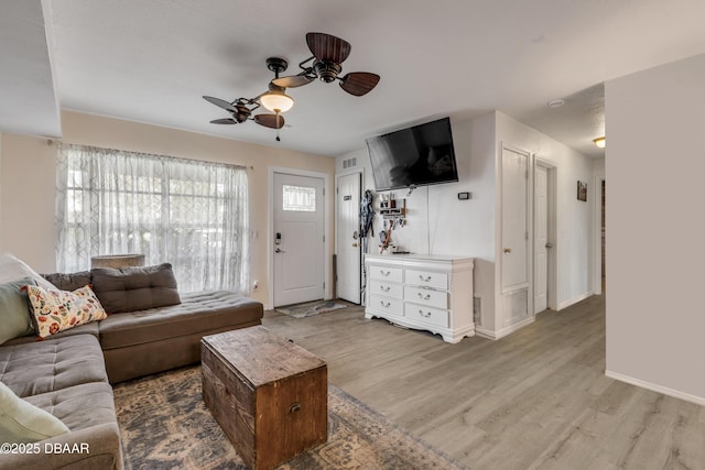 living area featuring visible vents, wood finished floors, a ceiling fan, and baseboards