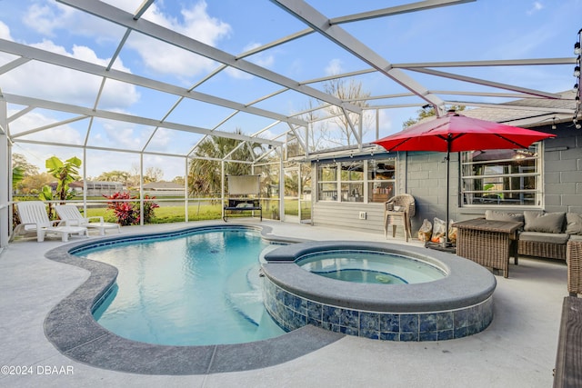 view of swimming pool featuring a patio area, a pool with connected hot tub, and glass enclosure