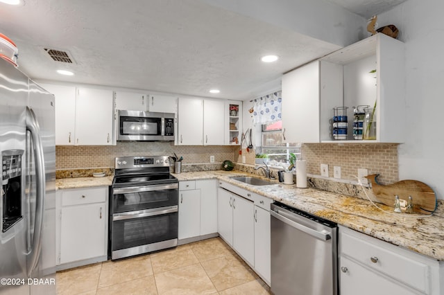 kitchen with a sink, visible vents, white cabinets, appliances with stainless steel finishes, and open shelves