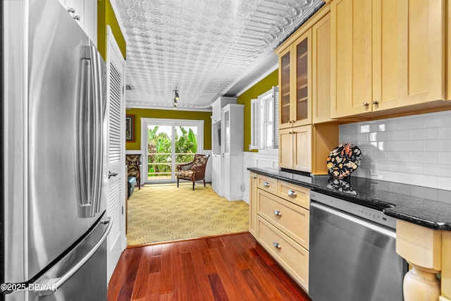4026 Cardinal Blvd, Wilbur-By-The-Sea, FL 32127 - kitchen featuring appliances with stainless steel finishes, glass insert cabinets, dark stone countertops, tasteful backsplash, and light brown cabinetry