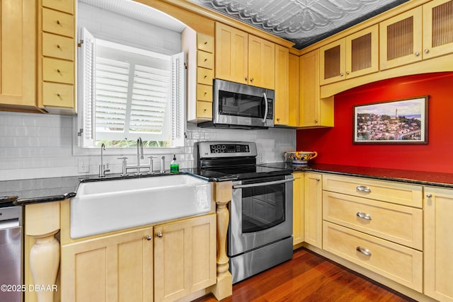 4026 Cardinal Blvd, Wilbur-By-The-Sea, FL 32127 - kitchen with stainless steel appliances, dark countertops, dark wood-type flooring, backsplash, and light brown cabinets