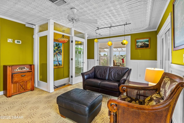 4026 Cardinal Blvd, Wilbur-By-The-Sea, FL 32127 - living area featuring crown molding, ceiling fan, light carpet, and a wainscoted wall