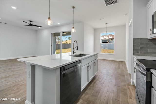 kitchen with sink, black appliances, an island with sink, light stone countertops, and white cabinets