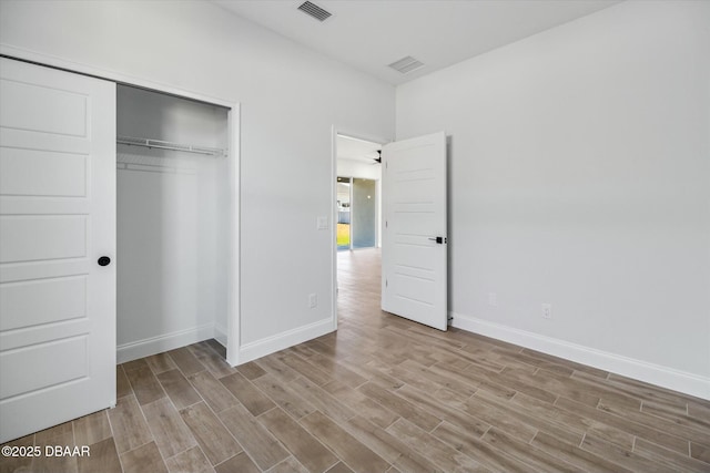 unfurnished bedroom with a closet and light hardwood / wood-style flooring