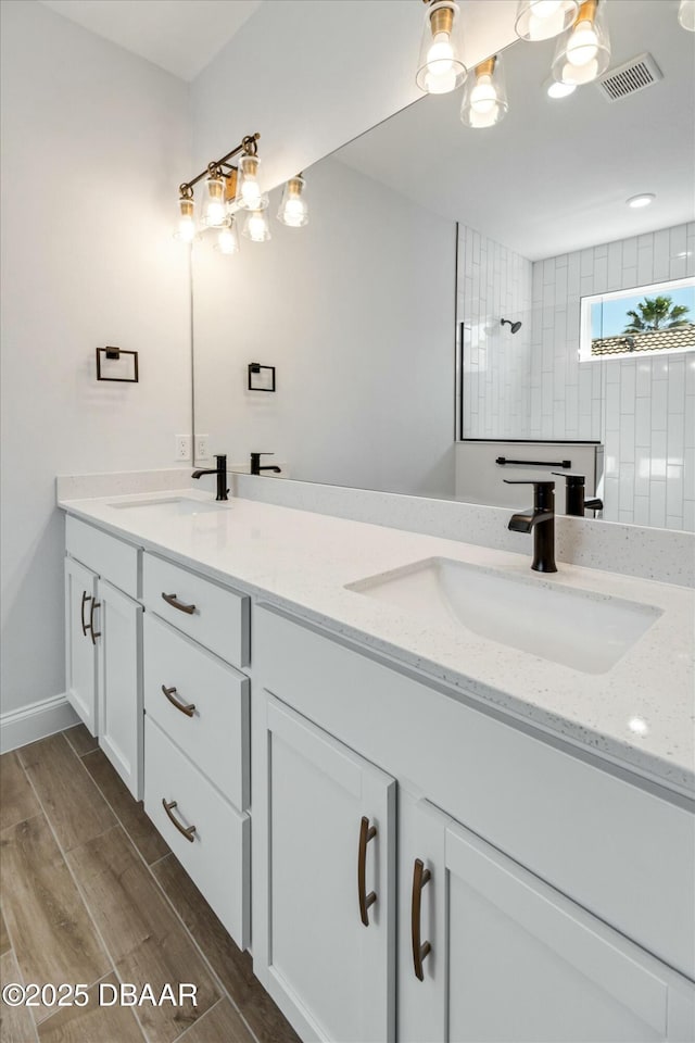 bathroom featuring vanity and tiled shower