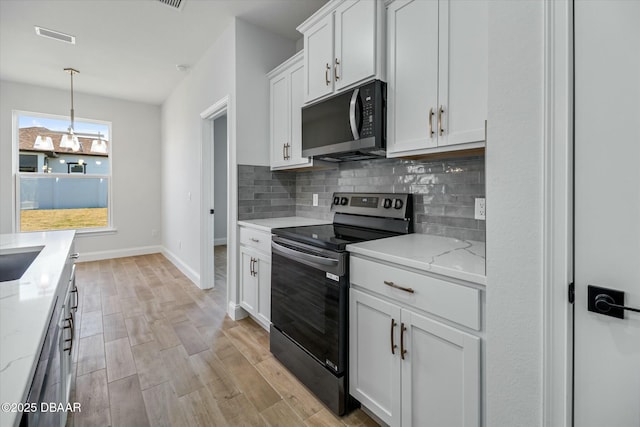 kitchen with white cabinetry, electric stove, light stone countertops, light hardwood / wood-style floors, and decorative backsplash