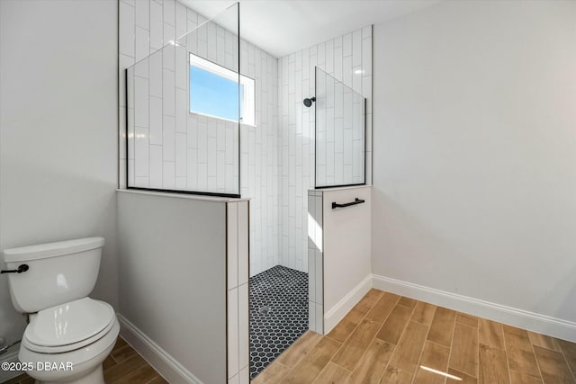 bathroom featuring a tile shower and toilet