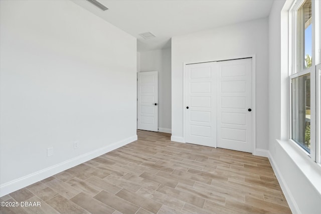 unfurnished bedroom with a closet and light hardwood / wood-style flooring